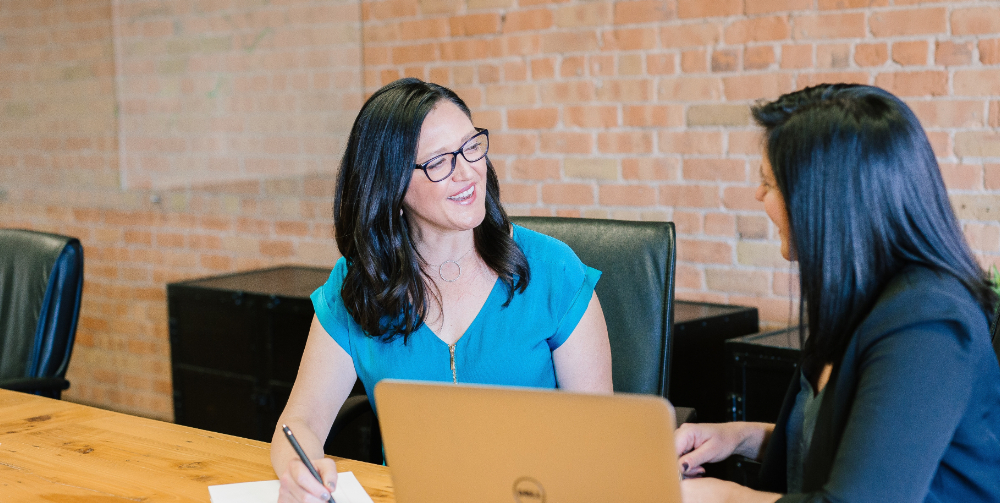 two woman looking at each other and talking