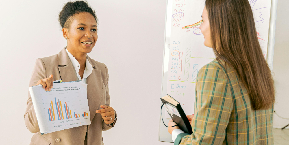 two women talking looking at graphs