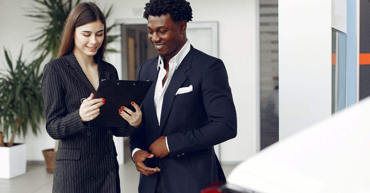 two people in suits looking at clipboard